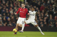 Manchester United's Luke Shaw, left vies for the ball with Leeds United's Crysencio Summerville during the English Premier League soccer match between Manchester United and Leeds United at Old Trafford in Manchester, England, Wednesday, Feb. 8, 2023. (AP Photo/Dave Thompson)