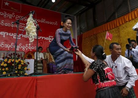 A woman of the Yin Net ethnic group gifts a traditional cloth to Myanmar pro-democracy leader Aung San Suu Kyi as Suu Kyi delivers a speech on voter education at the Hopong township in Shan state, Myanmar September 6, 2015. REUTERS/Soe Zeya Tun