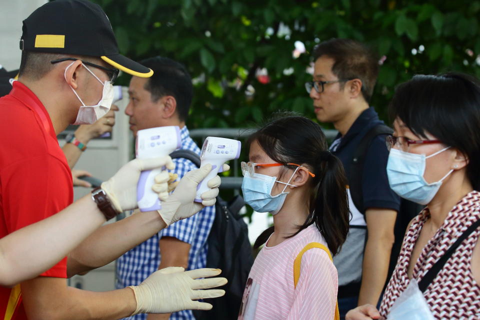 People undergo temperature checks at the entrance during the "Colours in Harmony" Chingay Parade at the F1 Pit Building on 31 January, 2020 in Singapore. (PHOTO: Getty Images)