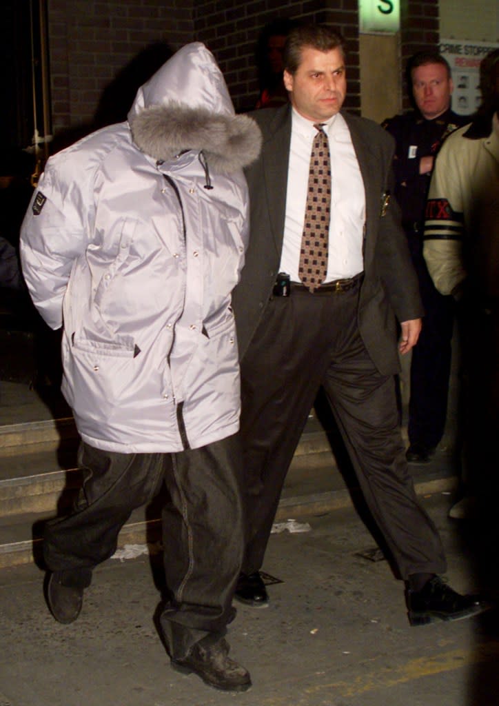 NYPD leads Combs out of a police station in handcuffs after his 1999 arrest with J.Lo. REUTERS