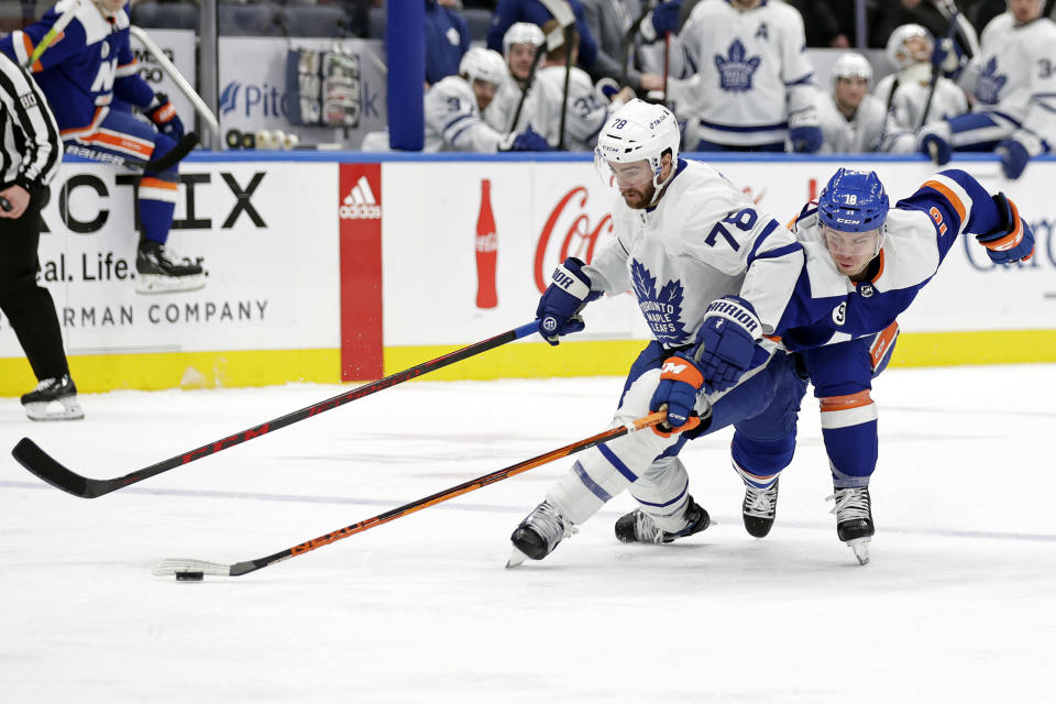 Toronto Maple Leafs defenseman TJ Brodie (78) and New York Islanders left wing Anthony Beauvillier battle for the puck in the second period of an NHL hockey game Saturday, Jan. 22, 2022, in Elmont, N.Y. (AP Photo/Adam Hunger)