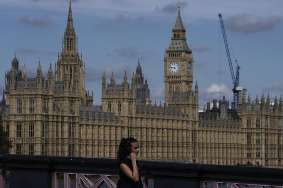 A woman walks past the Houses of Parliament in London, Monday, Sept. 11, 2023. Prime Minister Rishi Sunak has chastised China's premier for what he called unacceptable interference in British democracy after a newspaper reported that a researcher in Parliament was arrested earlier this year on suspicion of spying for Beijing. (AP Photo/Kin Cheung)