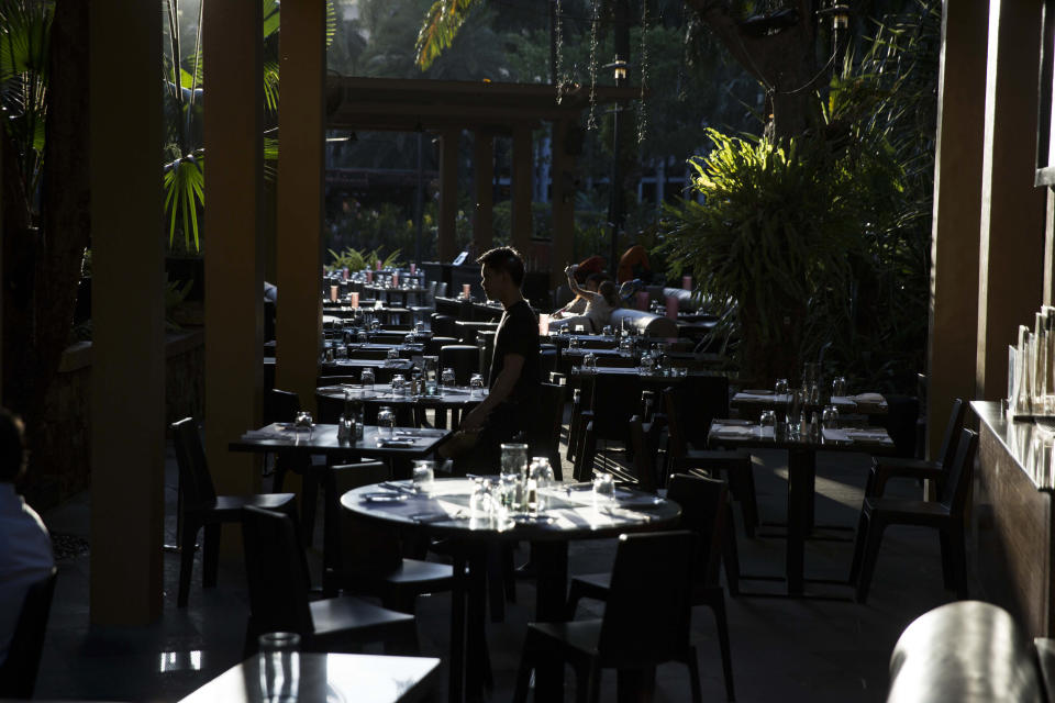 A silhouetted man walks past tables at a restaurant at Ayala Land Inc.’s Greenbelt shopping mall in Makati City, the Philippines. (Photo: Getty Images)