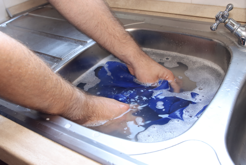 hand washing clothing in a sink