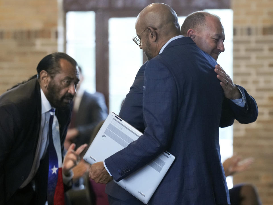 Jason Holt, descendant of PFC Thomas Hawkins, is hugged by Under Secretary of the Army, Gabe Camarillo, after talking about his great uncle's legacy, along with other soldiers from the 3rd Battalion, 24th Infantry Regiment, at Buffalo Soldiers Museum on Monday, Nov. 13, 2023, in Houston. U.S. Army officials say they will overturn the convictions of over 100 Black soldiers accused of a mutiny at a Houston military camp a century ago in a trial that had racial undertones. This comes after attorneys and advocates filed clemency petitions on behalf of the soldiers. (Elizabeth Conley/Houston Chronicle via AP)