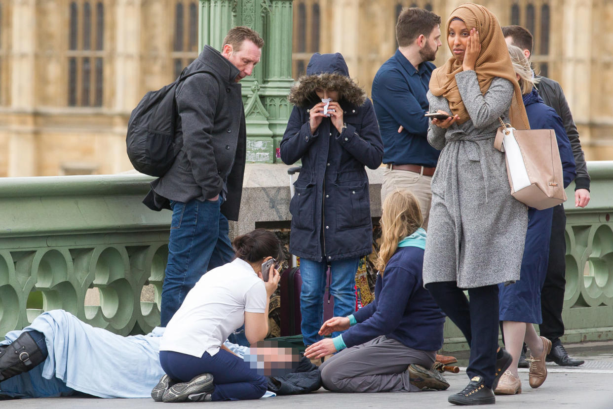 The visibly distressed woman walks past an injured person on Westminster Bridge: Jamie Lorriman