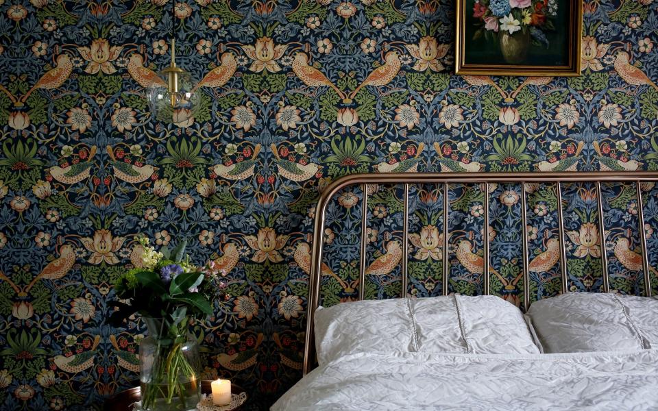 View of a bedroom papered with William Morris wallpaper