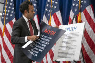 FILE - Republican presidential candidate Vivek Ramaswamy peels a sheet from a poster display as he speaks at the America First Policy Institute in Washington, Sept. 13, 2023. Ramaswamy's presidential campaign has seemingly mirrored his meteoric rise as a biotech entrepreneur. The political novice from Ohio has taken the route of a self-described outsider.((AP Photo/Mark Schiefelbein, File)