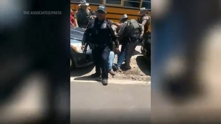 New video outside Robb Elementary School in Uvalde, Texas shows desperate parents being held back by police officers. (May 27)