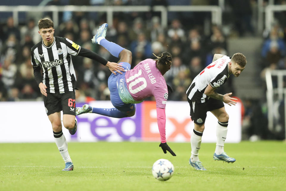 AC Milan's Rafael Leao, center, is flanked by Newcastle's Lewis Milley, left, and Newcastle's Kieran Trippier as in action during the Champions League group F soccer match between Newcastle United and AC Milan at St. James' Park, in Newcastle, England, Wednesday, Dec. 13, 2023. (AP Photo/Scott Heppell)