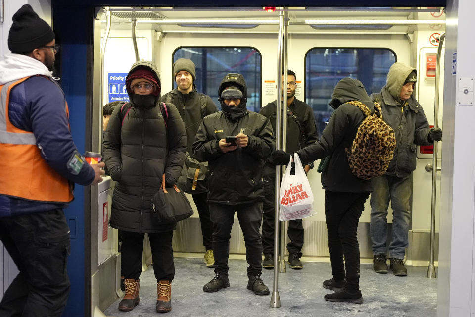 Travelers bundle up as they ride on an airport train at the O'Hare International Airport in Chicago, Sunday, Jan. 14, 2024. Wind chill warning is in effect as dangerous cold conditions continue in the Chicago area. (AP Photo/Nam Y. Huh)