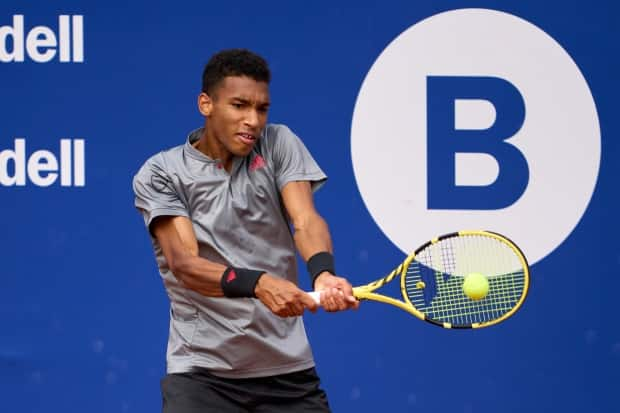 Canada's Felix Auger-Aliassime plays a backhand against fellow Canadian Denis Shapovalov in their third round match at the Barcelona Open Banc Sabadell 2021 in Barcelona on Thursday. (Alex Caparros/Getty Images - image credit)