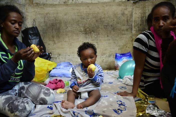 Ten-month-old Dan from Eritrea waits for food and supplies with his relatives a train station in Milan, Italy, on June 11, 2015 (AFP Photo/Olivier Morin)