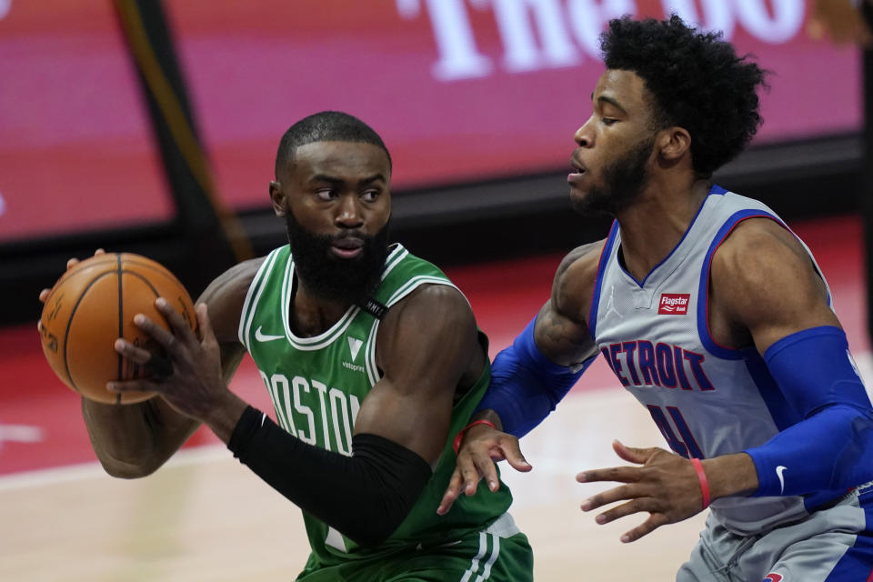 Boston Celtics guard Jaylen Brown looks to pass the ball as Detroit Pistons guard Saddiq Bey (41) defends during the first half of an NBA basketball game Friday, Jan. 1, 2021, in Detroit. (AP Photo/Carlos Osorio)