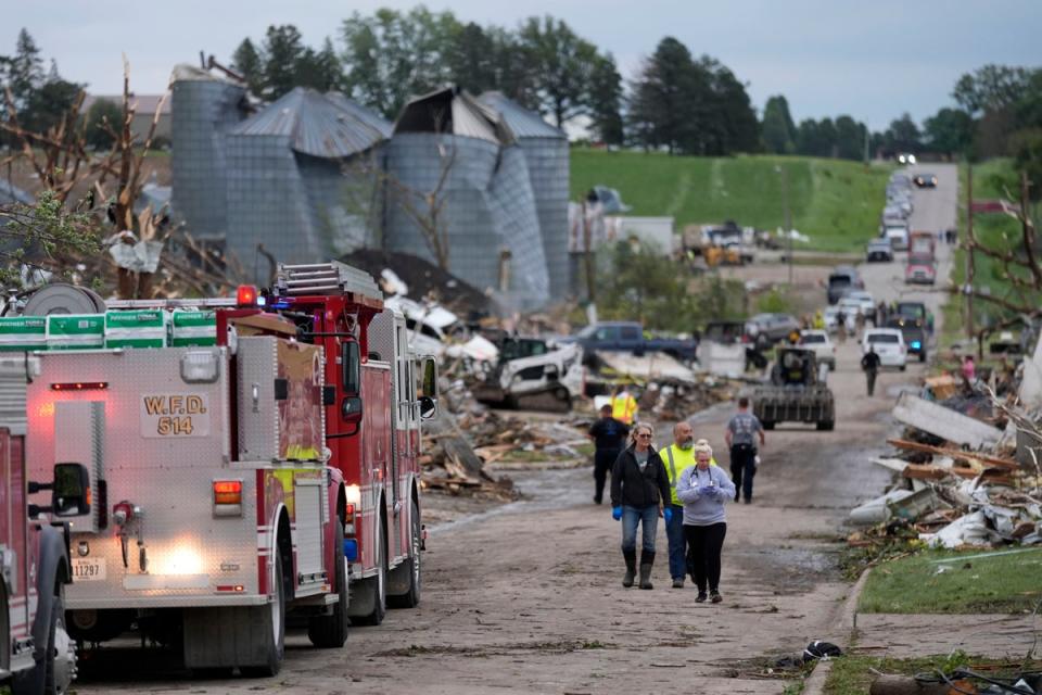 Rescue officials and residents walk down a street damaged by a tornado in Greenfield, Iowa, on Tuesday. The governor has committed to helping the town of just 2,000 rebuild (AP)