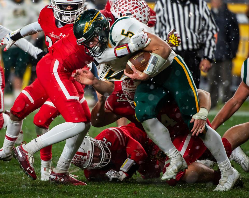 Penn-Trafford's Cade Yacamelli gets brought down by a pile of Moon defenders during the WPIAL 5A Championship Saturday at Heinz Field.[Lucy Schaly/For BCT]