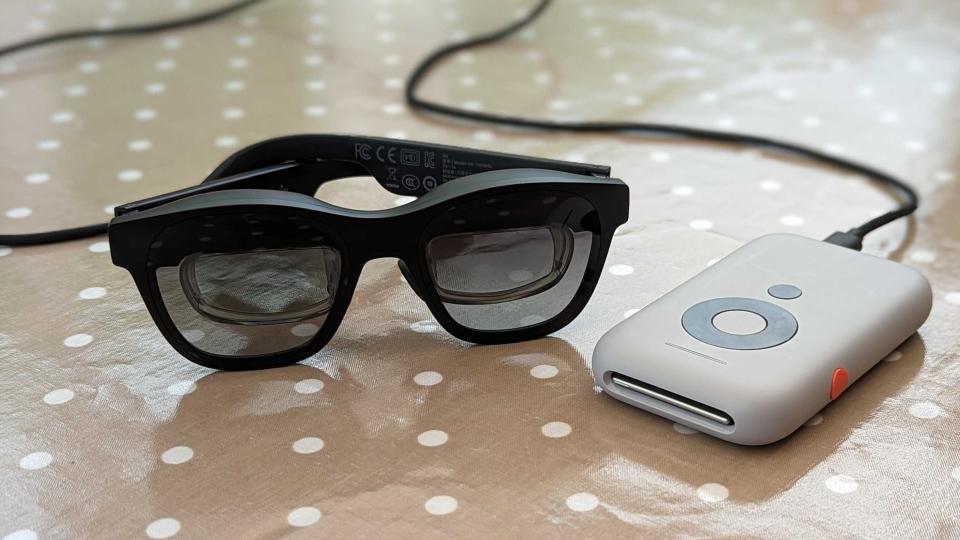 The Xreal Beam and Xreal Air glasses sat next to each other on a polka dot table cloth