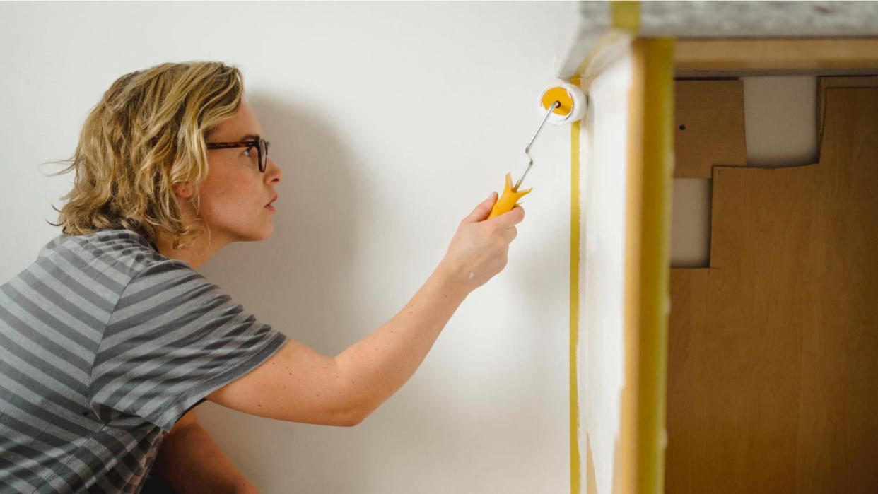 A woman painting cupboard