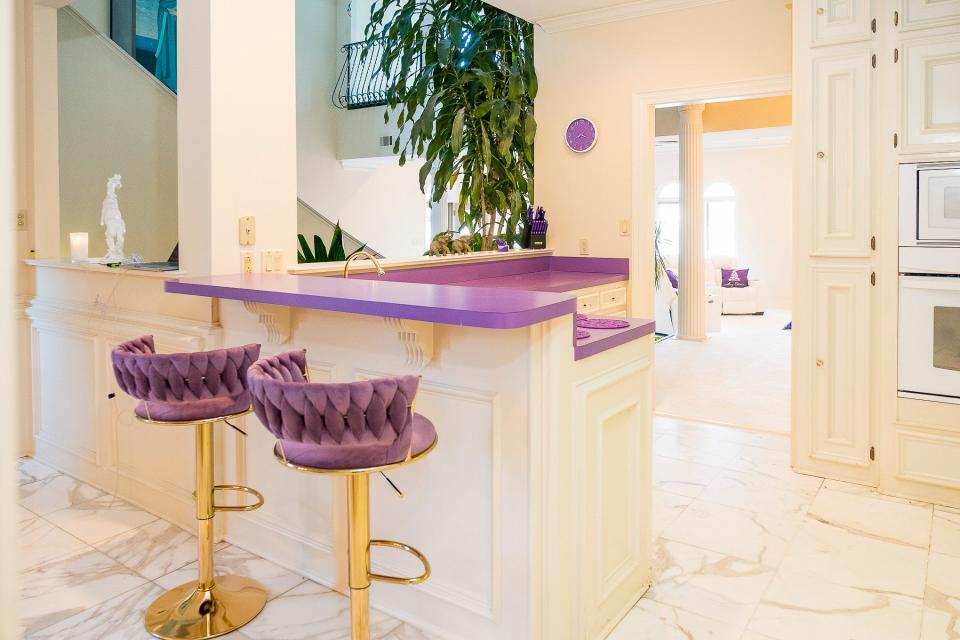 Purple countertops are coupled with tufted bar stools.