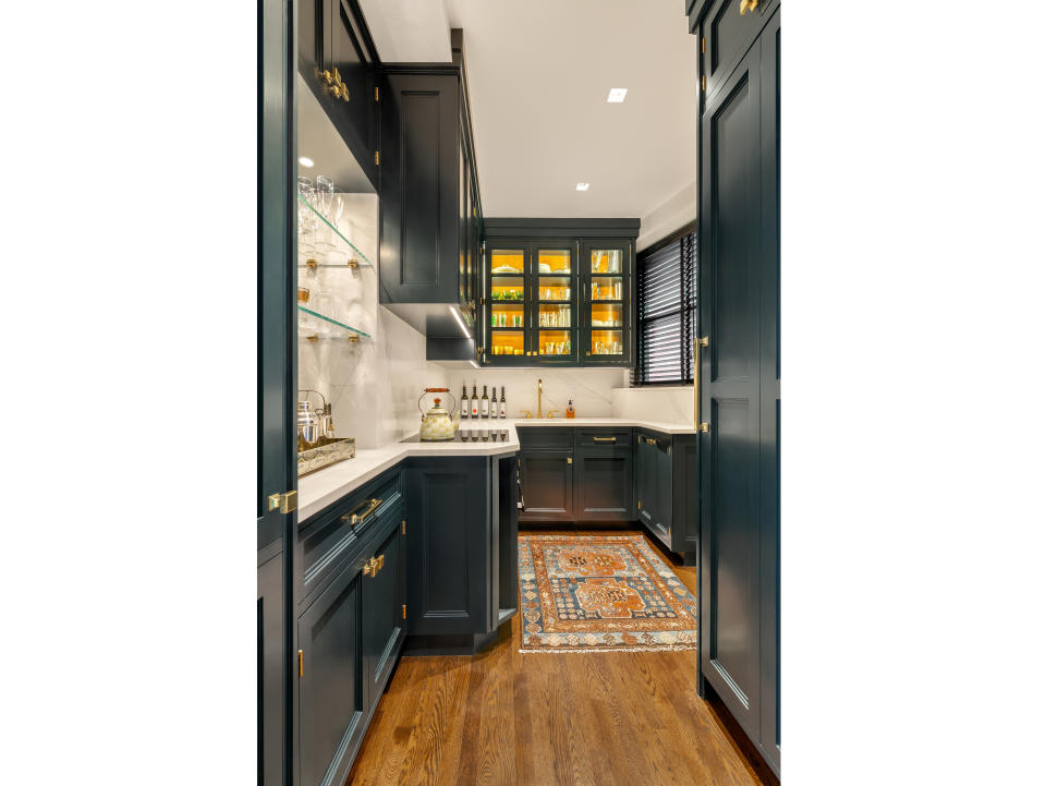 This image provided by Bakes & Kropp shows a pantry room with cabinetry in satin-finished Midnight Dream paint. Counters and backsplash are quartz, providing an attractive counterpoint. Once a relatively high-end kitchen feature, pantries are now increasingly popular as homeowners multi-task in the main kitchen area and want to get the clutter and messier aspects out of the way. (Allyson Lublow/Bakes & Kropp via AP)