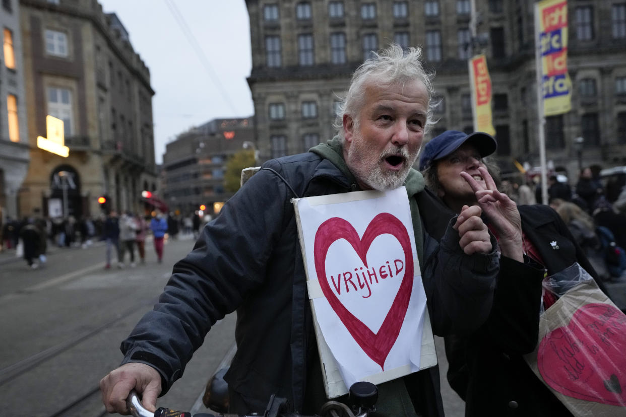 A protestor wears a sign reading "Freedom" during a demonstration against COVID-19 restrictions in Amsterdam, Netherlands, Saturday, Nov. 20, 2021. (AP Photo/Peter Dejong)