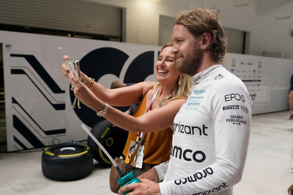 A fan takes a selfie with Aston Martin driver Sebastian Vettel after the first practice session of the Miami Grand Prix weekend.