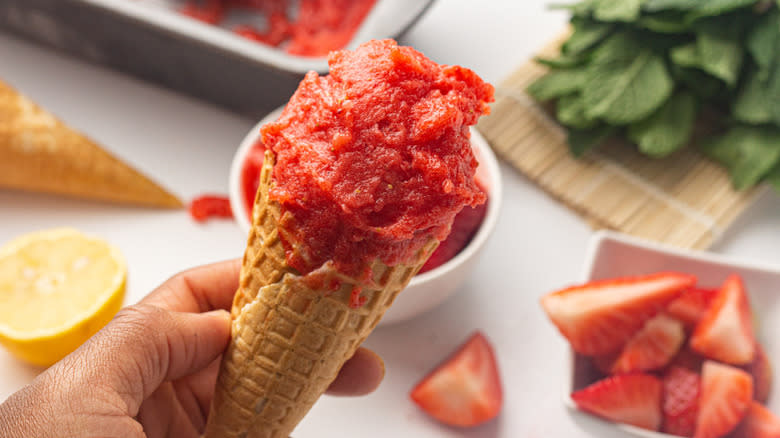 hand holding strawberry sorbet cone