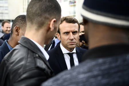 Emmanuel Macron (C), head of the political movement En Marche !, or Onwards !, and candidate for the 2017 presidential election, speaks with youths during a campaign visit in Sarcelles, near Paris, April 27, 2017. REUTERS/Martin Bureau/Pool