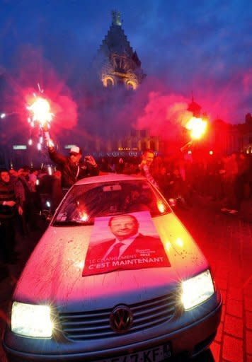 Supporters of France's Socialist Party (PS) newly elected president celebrate with smoke bombs from a car, at the Grande Place in Lille after the announcement of the first official results of the second round of Presidential election