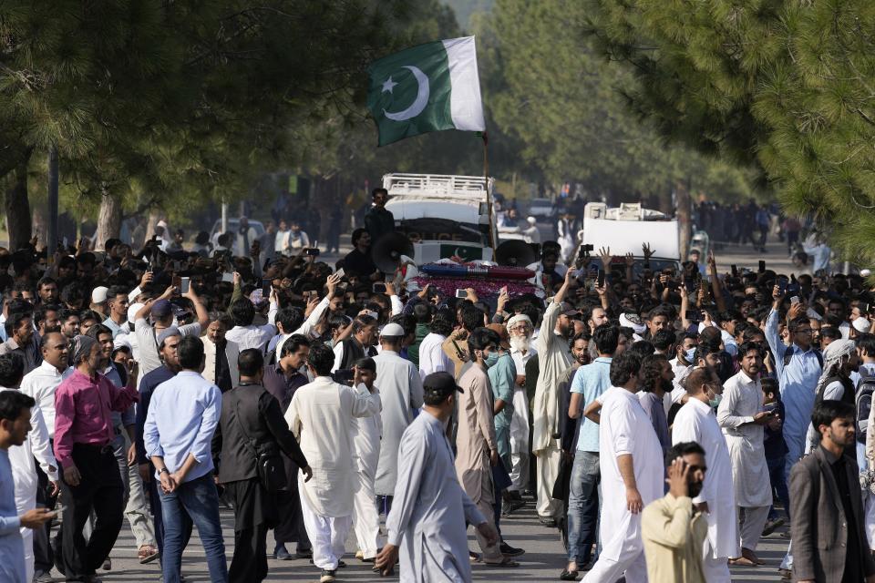 People walk with an ambulance carrying the casket of slain senior Pakistani journalist Arshad Sharif after his funeral prayer, in Islamabad, Pakistan, Thursday, Oct. 27, 2022. Thousands of mourners in the capital, Islamabad on Thursday attended the funeral of the outspoken Pakistani journalist who was shot and killed by Nairobi police, as the spy chief and the military spokesman paid tributes to him because of his journalistic work and demanded a probe into his killing. (AP Photo/Anjum Naveed)