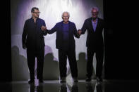 Fashion designer Giorgio Armani is flanked by Gianluca Dell'Orco, from the style studio, and Leo Dell'Orco at the end of the Giorgio Armani Men's Spring Summer 2025 fashion show, that was presented in Milan, Italy, Monday, June 17, 2024. (AP Photo/Luca Bruno).