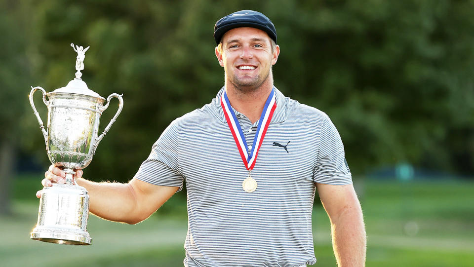 Bryson DeChambeau (pictured) smiles while holding the US championship trophy.