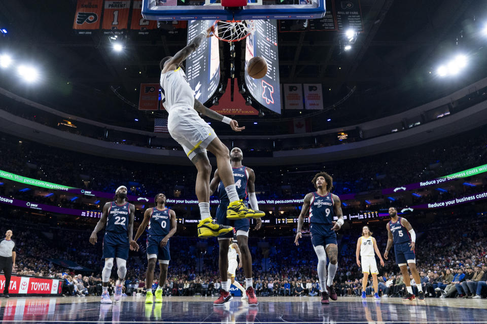 Utah Jazz's John Collins, foreground, dunks against the Philadelphia 76ers during the first half of an NBA basketball game Saturday, Jan. 6, 2024, in Philadelphia. The Jazz won 120-109. (AP Photo/Chris Szagola)