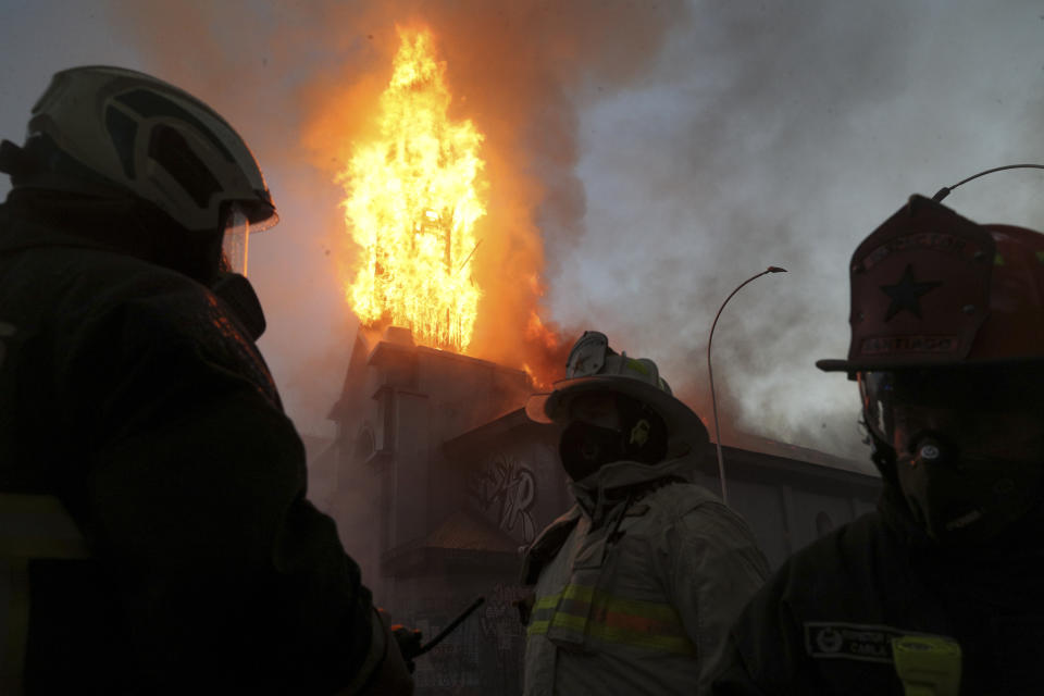 Bomberos combaten las llamas en la Parroquia de La Asunción después de que un grupo de personas le prendiera fuego en el primer aniversario del estallido social que sacudió al país en Santiago de Chile el domingo 18 de octubre de 2020. (AP Foto/Esteban Felix)