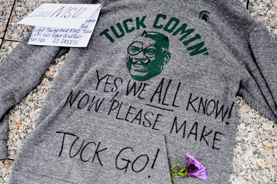 A defaced Mel Tucker sweatshirt with a note protesting the football coach is placed on the ground outside the Hannah Administration Building on Sept. 10 in East Lansing, Mich.
