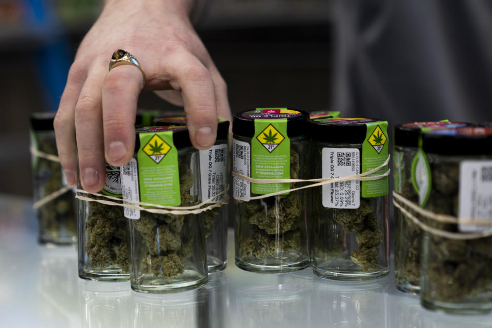 An employee puts away product at Cloud 9 Cannabis, Thursday, Feb. 1, 2024, in Arlington, Wash. Cloud 9 is one of the first dispensaries to open under the Washington Liquor and Cannabis Board's social equity program, established in efforts to remedy some of the disproportionate effects marijuana prohibition had on communities of color. (AP Photo/Lindsey Wasson)