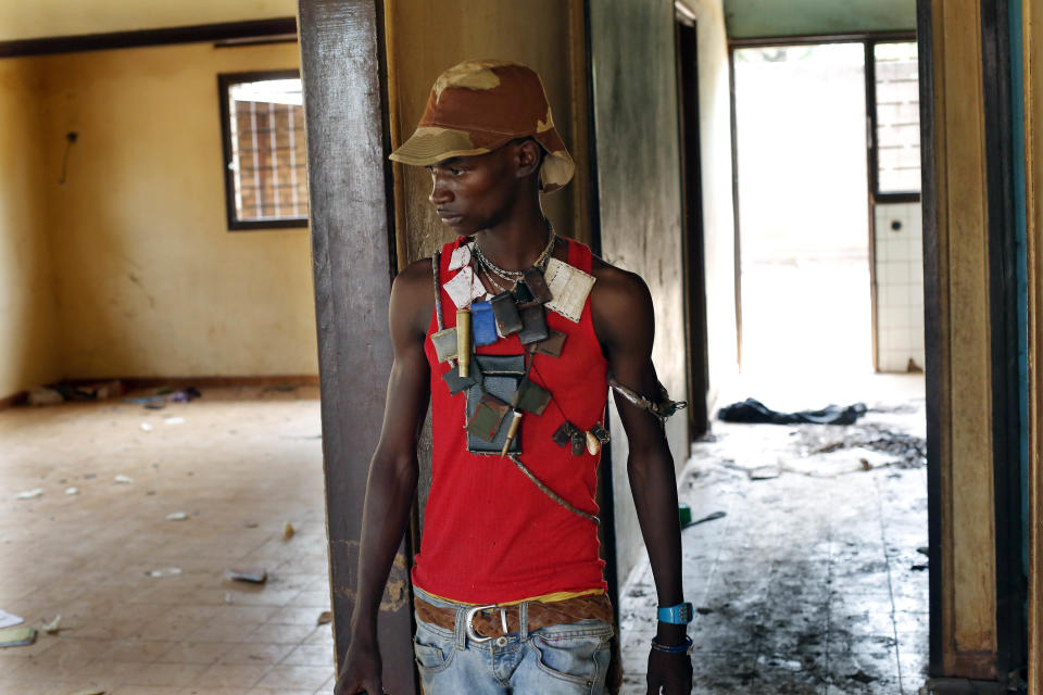 An Anti-Balaka militiaman stands in a looted house belonging to a Muslim man who fled the night before in Bangui, Central African Republic, Monday Feb. 3, 2014. Fighting between Muslim Seleka militias and Christian Anti-Balaka factions continues as French and African Union forces struggle to contain the bloodshed. (AP Photo/Jerome Delay)