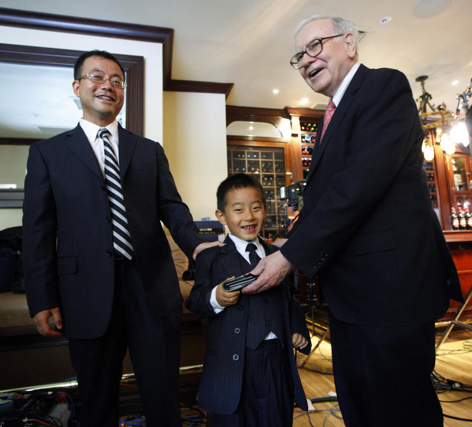 Hedge fund manager Zhao Danyang (L) and his son Zhao Ziyang (age 5 1/2) stand with billionaire investor Warren Buffett after placing the winning bid in a charity auction for lunch with Buffett in New York, June 24, 2009. Buffett, the Omaha, Nebraska-based chief executive officer of Berkshire Hathaway, handed his wallet to the younger Zhao and then whispered him a stock tip as they passed by photographers after completing television interviews at New York's famous steak house, Smith&Wollensky.     REUTERS/Chip East   (UNITED STATES BUSINESS SOCIETY)