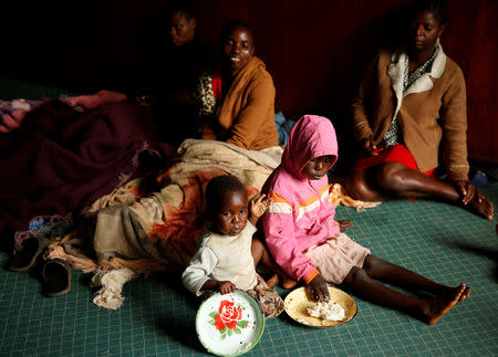 Survivors of Cyclone Idai eat food at a temporary shelter at a hotel in Chimanimani, Zimbabwe, March 23, 2019. REUTERS/Philimon Bulawayo