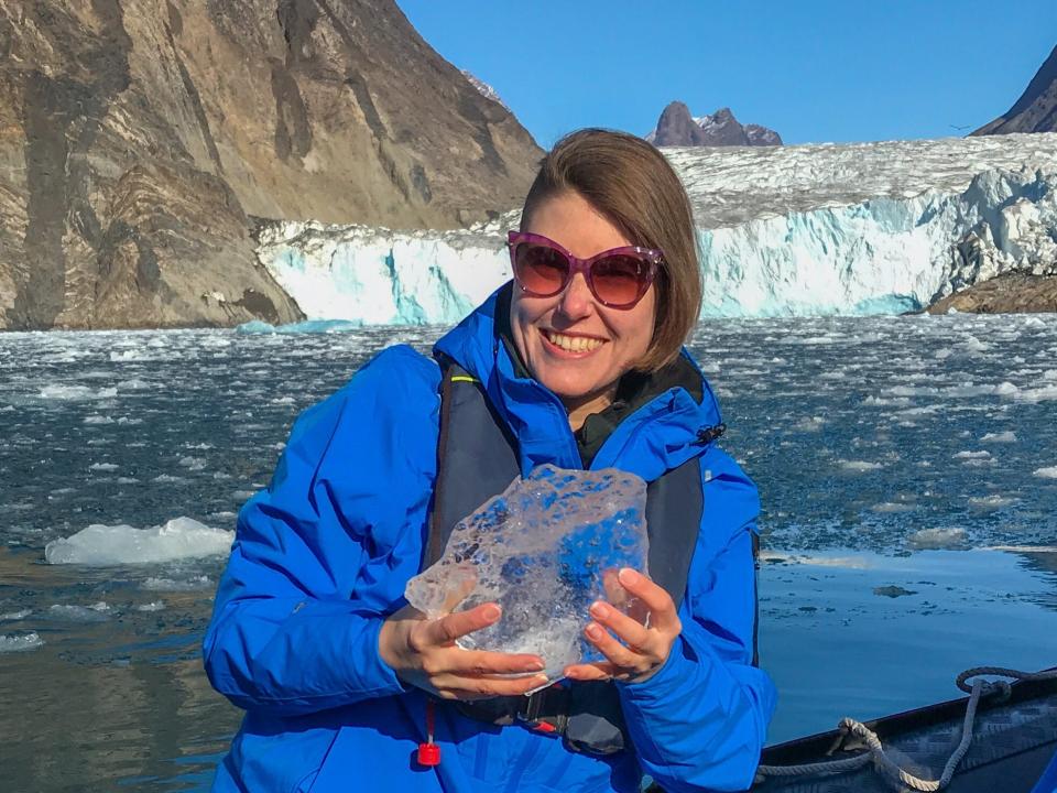 Die Autorin hält ein Stück Eisberg während einer Zodiacfahrt in der Arktis. - Copyright: Cassandra Brooklyn