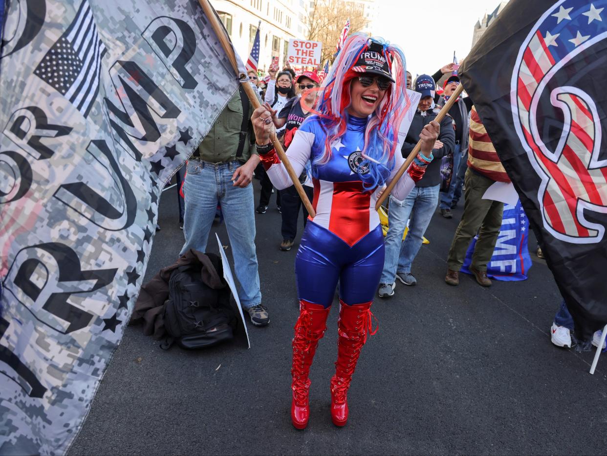<p>Trump supporters protest the election with Q-Anon flags</p> (REUTERS)
