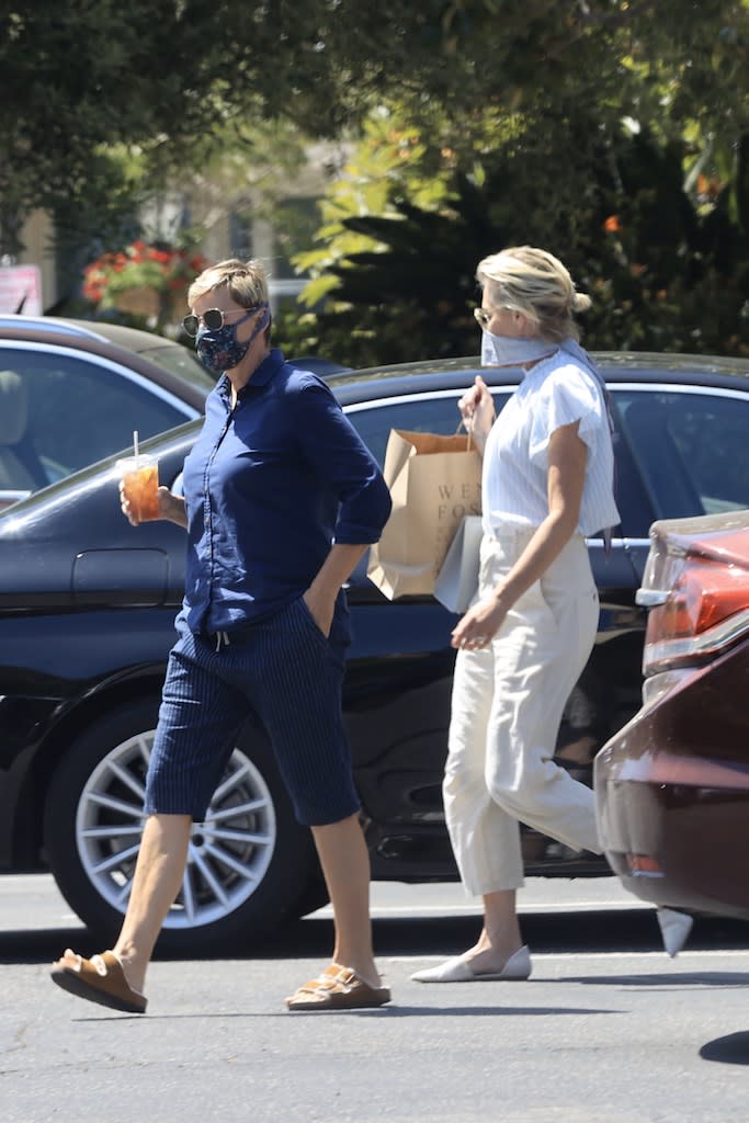 EXCLUSIVE: Ellen DeGeneres and Portia DeRossi who have been staying inside their fancy home in Santa Barbara, take a break from being cooped up what Ellen described as, her "prison" and head out in their convertible Porsche. The 62 year-old comedian and her 47 year-old wife are spotted enjoying a bit of a wander around Santa Barbara on Memorial Day while wearing masks to guard against possible spreading coronavirus. Seen here heading back to their car, Portia is carrying a bag from Wendy Foster where she seemed like one particular dress. She'd modeled it for Ellen, who pulled her mask down to drink her iced-tea while watching. 23 May 2020 Pictured: Ellen Degeneres, Portia DeRossi. Photo credit: Rachpoot/P&P/MEGA TheMegaAgency.com +1 888 505 6342 (Mega Agency TagID: MEGA670855_001.jpg) [Photo via Mega Agency]