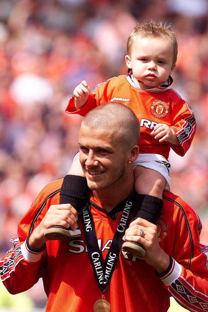 David Beckham holding his son