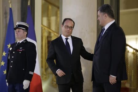 French President Francois Hollande reacts as he speaks with Ukraine's President Petro Poroshenko (R) after a summit on the crisis in Ukraine at the Elysee Palace in Paris, France, October 2, 2015. REUTERS/Philippe Wojazer