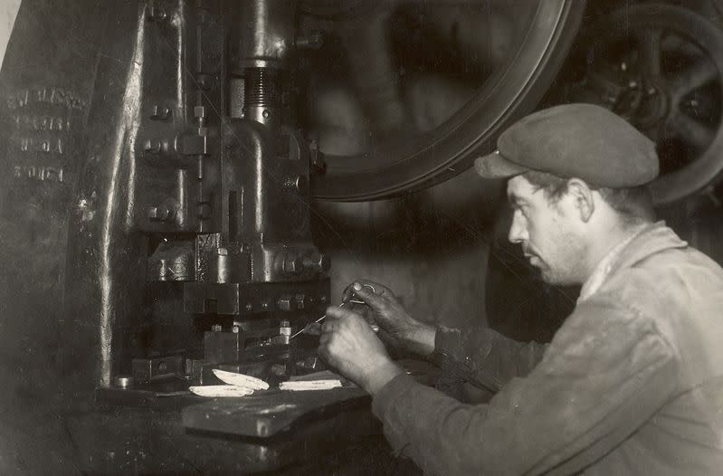 A worker puts together knives in the Opinel factory, 1930