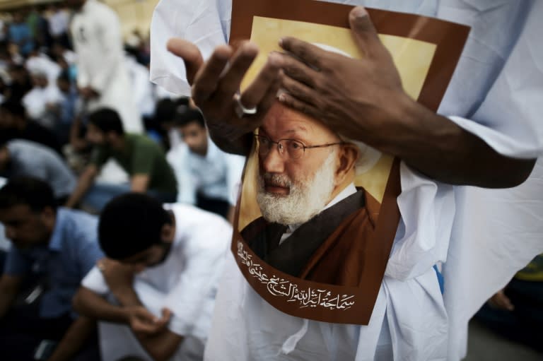 Bahraini demonstrators attend a protest in support of senior Bahraini Shiite cleric Sheikh Isa Qassim (portrait), on June 20, 2016 near Qassim's house in the village of Diraz, west of Manama