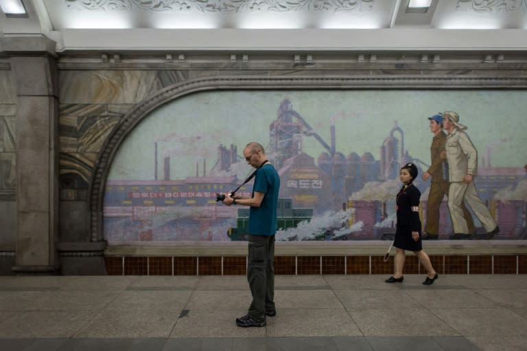 A tourist takes a photo during a visit to a subway station in Pyongyang