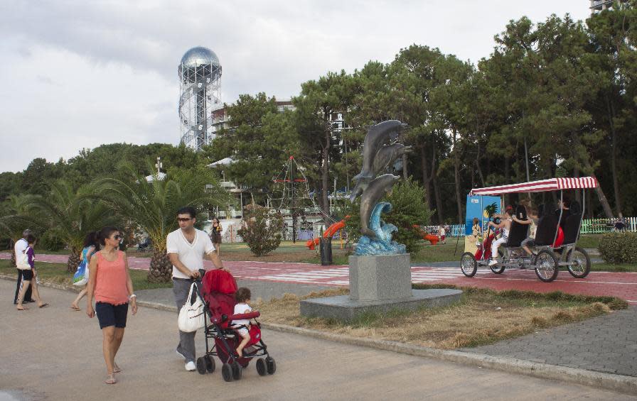 In this Aug. 1, 2012, photo , a man and a woman take a stroll with their child along the embankment in Georgia's Black Sea resort city of Batumi. The transformation of Batumi, an ancient city of 180,000 near the border with Turkey, is a vivid example of Georgia’s drive to capitalize on its tourism potential in a bid to boost the economy in this struggling ex-Soviet nation, where nearly 1/5 of the population lives in poverty, according to conservative estimates. The government has attracted top foreign investors, such as U.S. estate magnate Donald Trump, to build hotels and develop and renovate tourist sites and aggressively marketed Georgia as tourism hot spot abroad. (AP Photo/Maria Danilova)