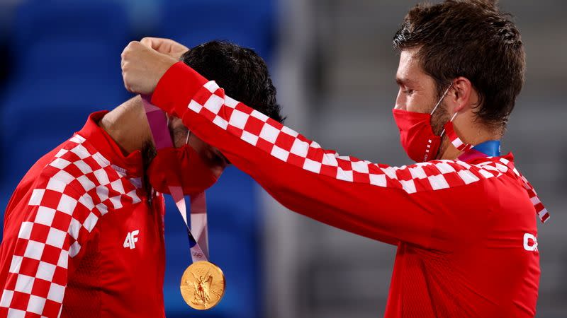 Foto del viernes de los croatas Mate Pavic y Nikola Mektic en el podio tras ganar el oro en el dobles masculino de tenis.