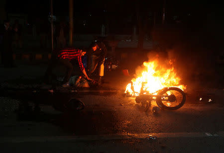 People check the condition of a victim after a blast in Lahore, Pakistan February 13, 2017. REUTERS/Mohsin Raza